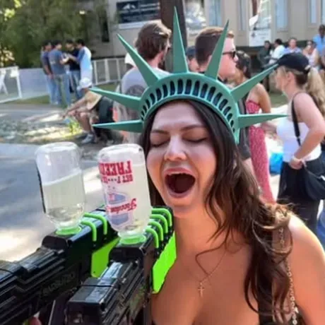 A festival-goer in a Statue of Liberty crown at the Freedom Juice squirt rig