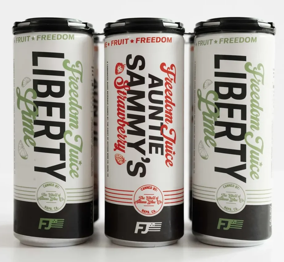 Three 12 oz cans of Freedom Juice sparkling agave wine — two Liberty Lime and one Auntie Sammy's Strawberry